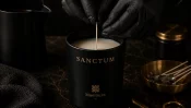 Handgefertigte Maelōura Duftkerze SANCTUM beim präzisen Setzen des Baumwolldochts.